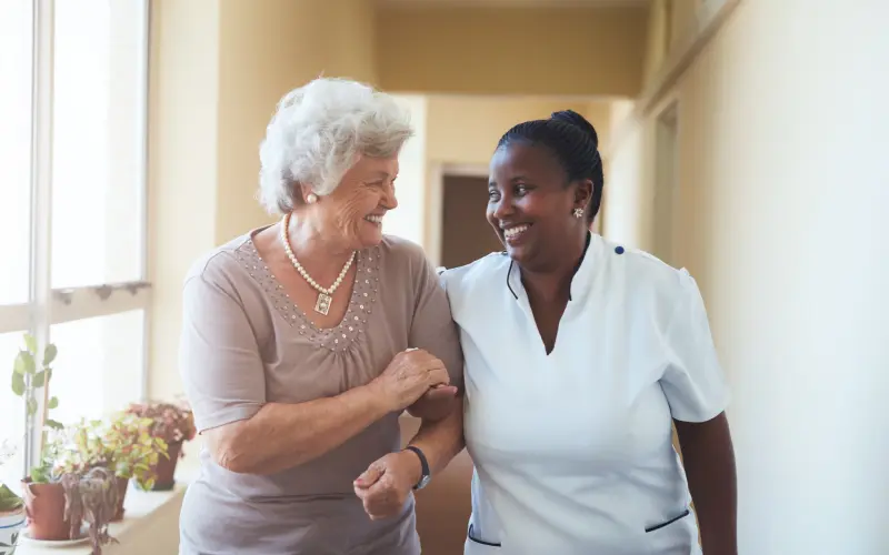 Two women are smiling and holding hands.