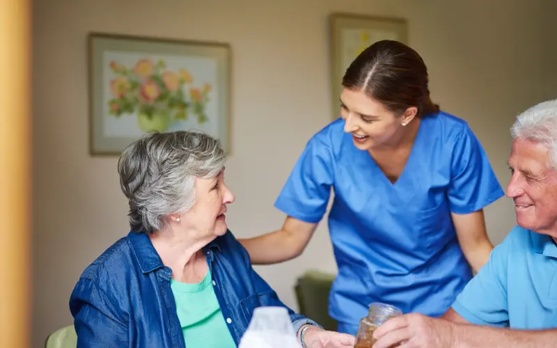 A nurse is helping an elderly woman with her medicine.