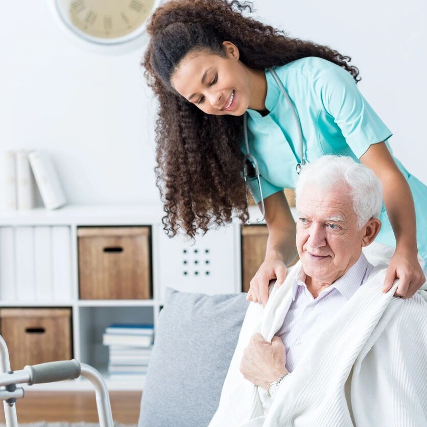 A woman helping an older man to get up.